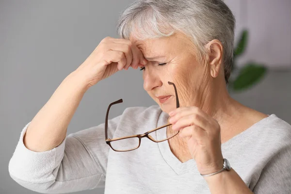 Idős nő szenved fejfájás otthon — Stock Fotó