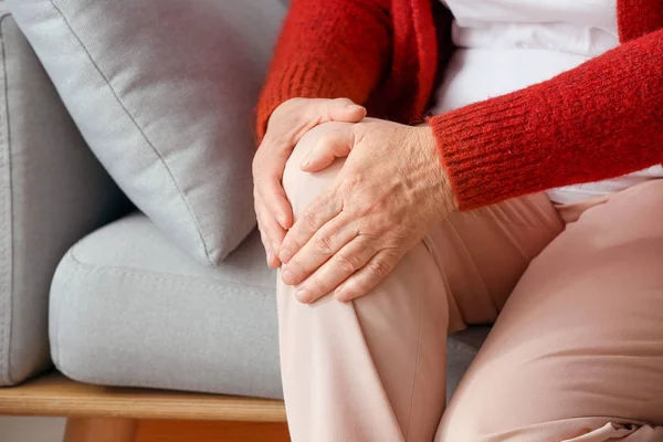 Starší žena trpící bolestí kolena doma, detailní záběr — Stock fotografie