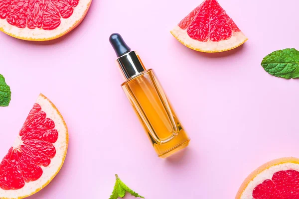 Composición con aceite esencial de pomelo sobre fondo de color —  Fotos de Stock