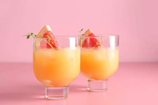 Glasses of fresh citrus juice on color background — Stock Photo, Image