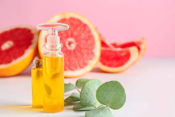 Bottles of grapefruit essential oil on table — Stock Photo, Image