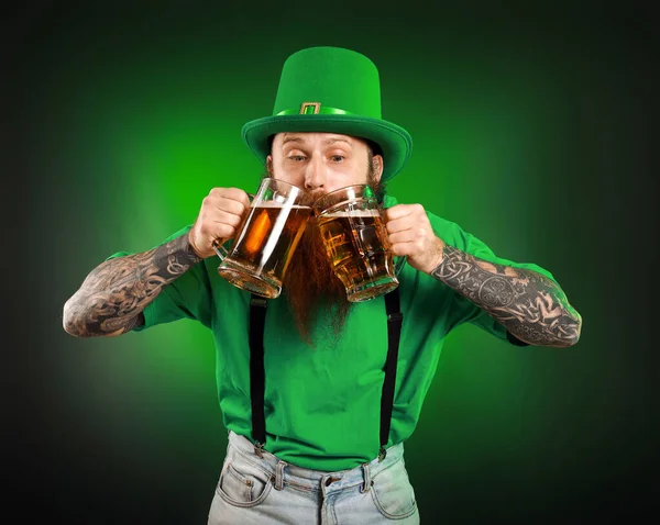 Homme barbu avec des verres de bière sur fond sombre. Célébration de la Saint Patrick — Photo