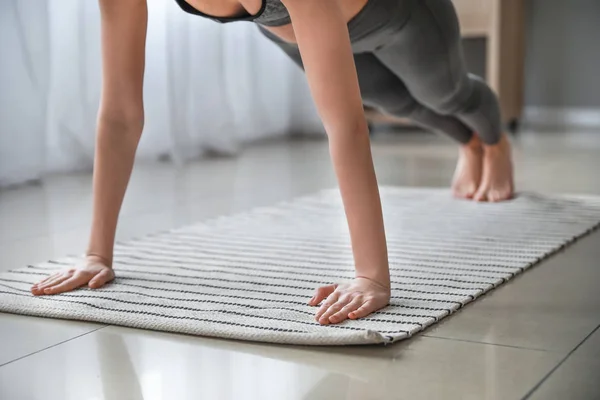 Beautiful young woman practicing yoga at home — Stock Photo, Image