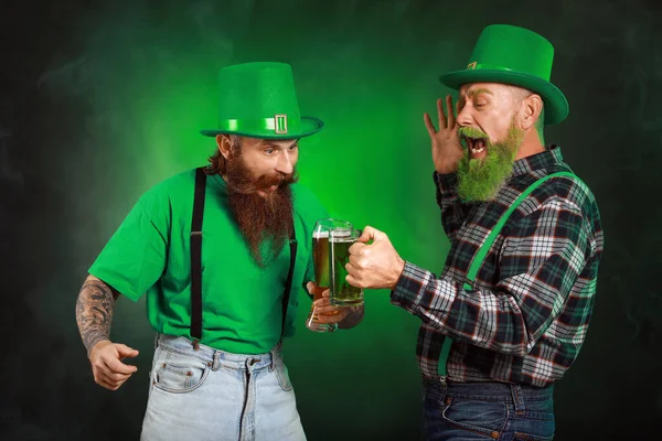 Bärtige Männer mit Biergläsern auf dunklem Hintergrund. St. Patrick 's Day Feier — Stockfoto