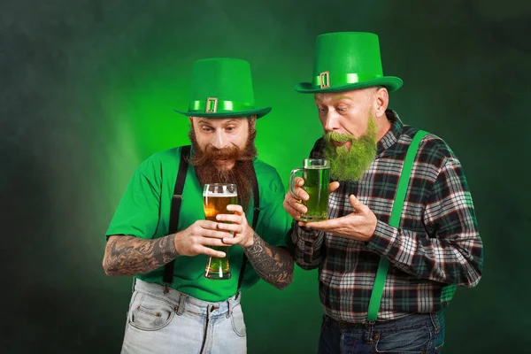 Uomini barbuti con bicchieri di birra su sfondo scuro. Festa di San Patrizio — Foto Stock