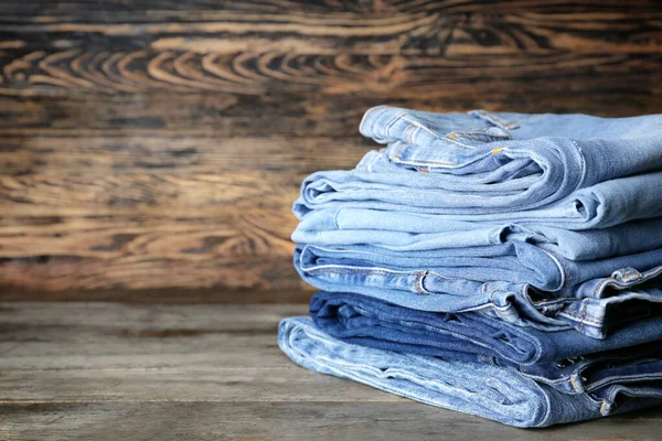 Stack of clean clothes on wooden table — Stock Photo, Image