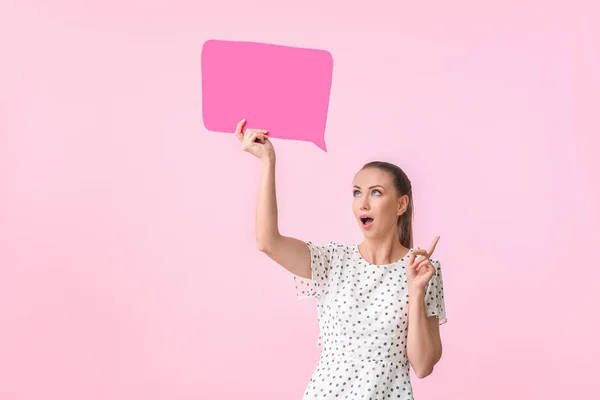 Young woman with blank speech bubble and raised index finger on color background — Stock Photo, Image