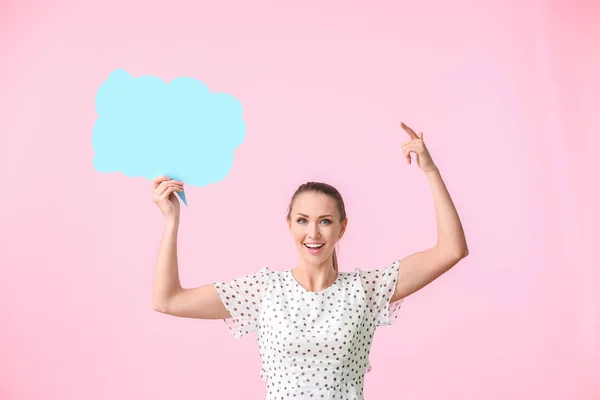 Young woman with blank speech bubble on color background — Stock Photo, Image