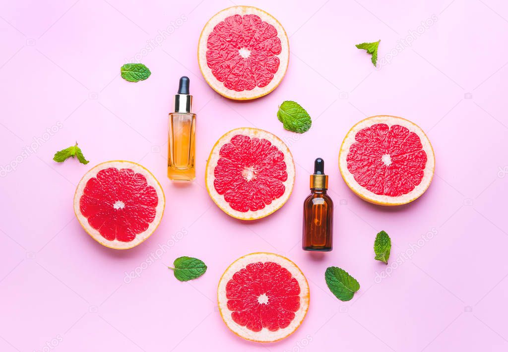 Composition with grapefruit essential oil on color background