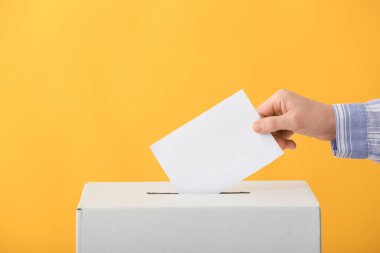 Renkli arka planda oy sandığının yanında oy veren kadın