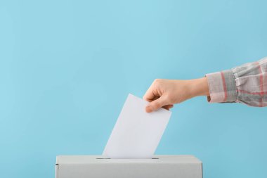 Renkli arka planda oy sandığının yanında oy veren kadın