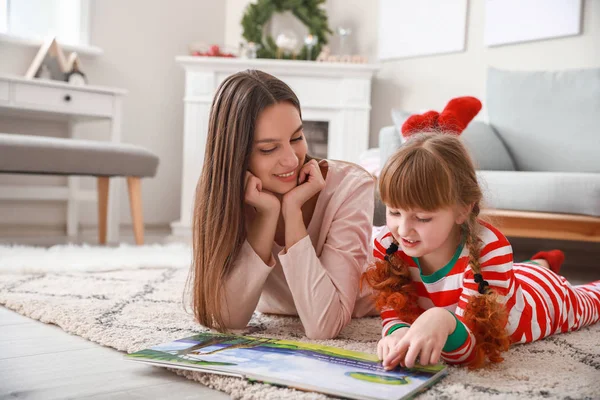 Klein meisje met moeder lezen boek thuis — Stockfoto