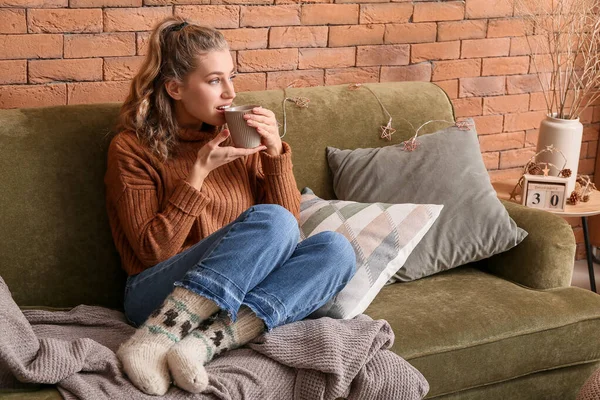 Jovem feliz em roupas de inverno bebendo chocolate quente em casa — Fotografia de Stock