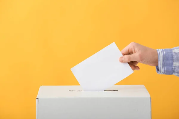 Mulher votante perto da urna no fundo de cor — Fotografia de Stock