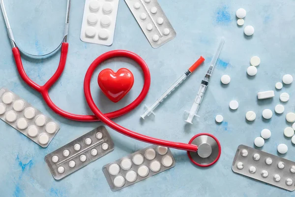 Stethoscope, heart and pills on light background. Cardiology concept — Stock Photo, Image