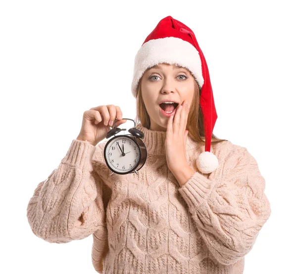 Överraskad ung kvinna i Santa hatt och med väckarklocka på vit bakgrund. Julnedräkning koncept — Stockfoto