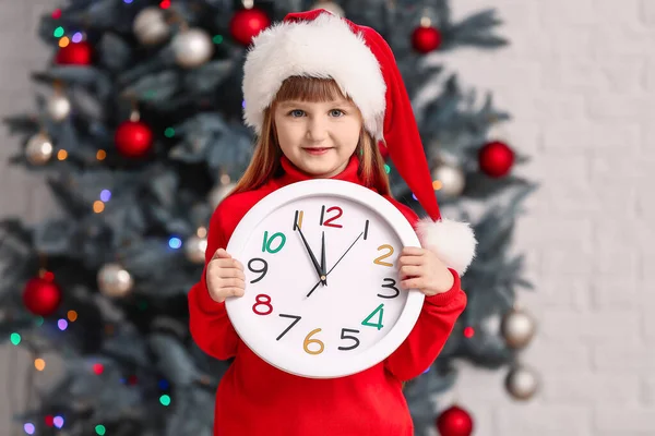 Κοριτσάκι με καπέλο και ρολόι στο σπίτι. Χριστούγεννα αντίστροφη μέτρηση έννοια — Φωτογραφία Αρχείου