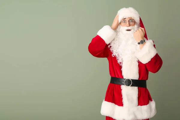 Père Noël surpris avec montre sur fond de couleur. Concept de compte à rebours de Noël — Photo