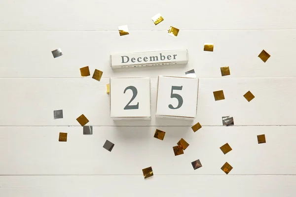 Calendar with date of Christmas and confetti on wooden background — Stock Photo, Image