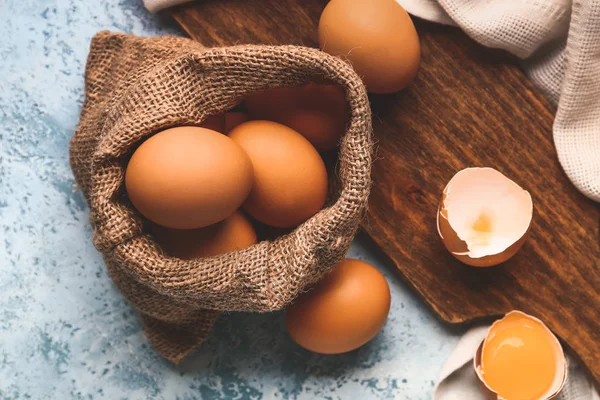 Sack with fresh eggs on color background — Stock Photo, Image
