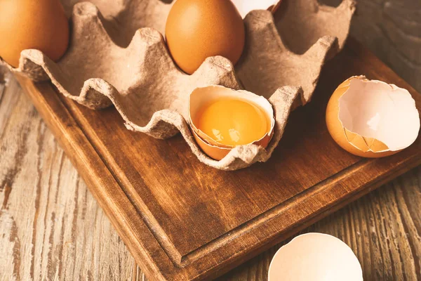 Pakket met verse eieren op houten tafel — Stockfoto