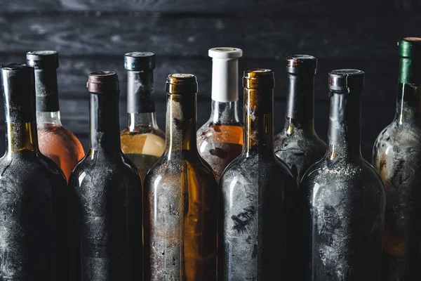 Bottles of wine on dark wooden background — Stock Photo, Image