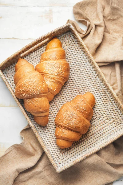 Bricka med goda croissanter på vitt bord — Stockfoto