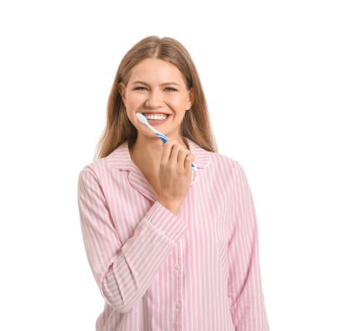 Beyaz arka planda dişlerini fırçalayan genç bir kadın