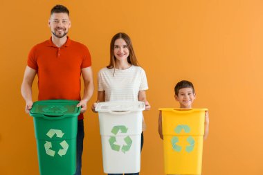 Renkli arka planda çöp konteynırları olan bir aile. Geri dönüşüm kavramı