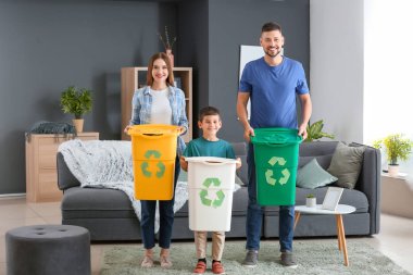 Evde çöp konteynırları olan bir aile. Geri dönüşüm kavramı
