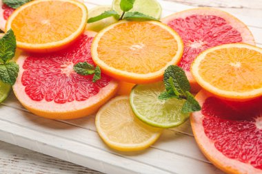 Fresh cut citrus fruits on wooden background