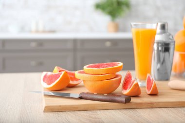 Mutfak masasında taze kesilmiş greyfurtlu kompozisyon.