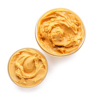 Beyaz arka planda kâselerde lezzetli fıstık ezmesi