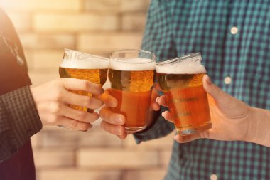 İnsanlar içeride bira bardaklarını tokuşturuyor.