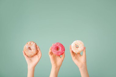 Renkli donutları olan kadın elleri