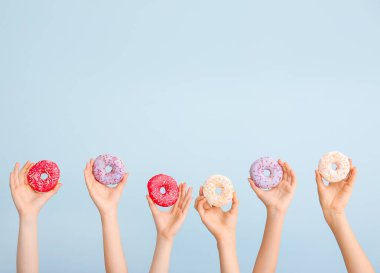 Renkli donutları olan kadın elleri