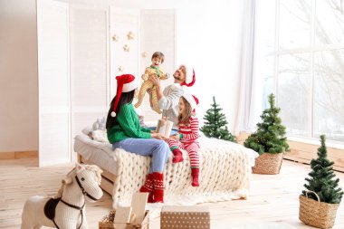 Mutlu aile Noel arifesinde yatak odasında dinleniyor.