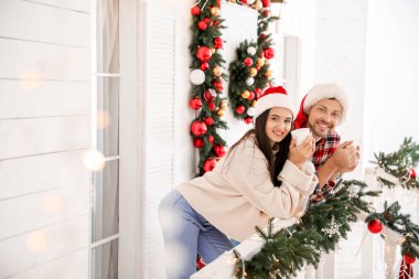 Mutlu çift verandada çay içiyor Noel için süslenmiş.