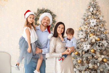 Mutlu aile Noel için dekore edilmiş odada.