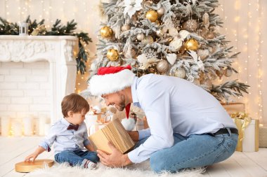 Mutlu baba ve küçük oğlu Noel hediyesini evde açıyorlar.
