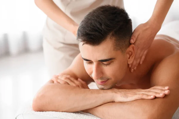 Pohledný muž s masáží v salonu spa — Stockfoto