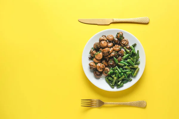 Talerz ze smacznymi gotowanymi grzybami i zieloną fasolą na tle koloru — Zdjęcie stockowe