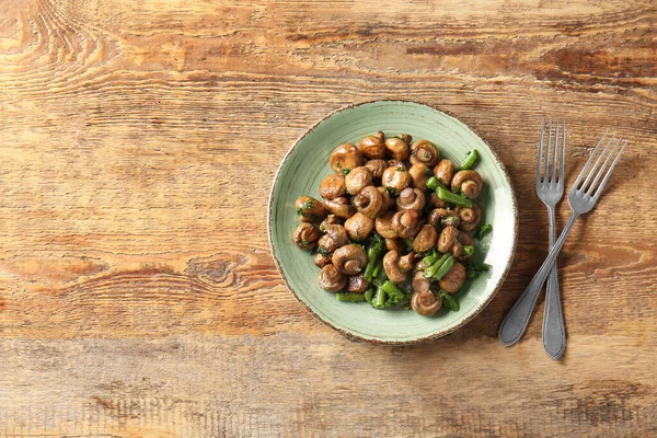 Plate with tasty cooked mushrooms and green beans on table — Stock Photo, Image