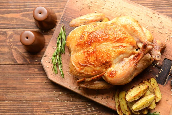 Tábla sült csirkével és burgonyával a fa asztalon — Stock Fotó