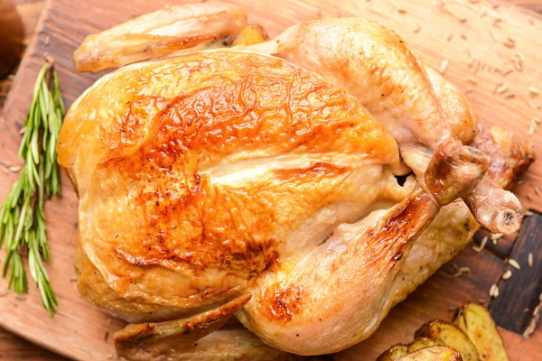 Запечённая курица на деревянной доске — стоковое фото