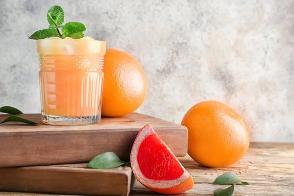 Glass of juice and fresh grapefruits on table — Stock Photo, Image