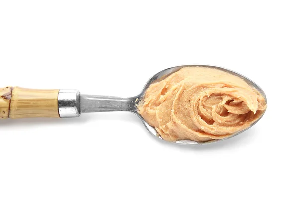 Ложка с вкусным арахисовым маслом на белом фоне — стоковое фото