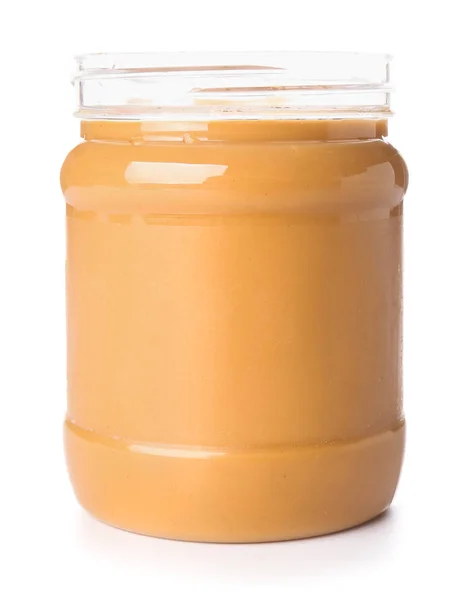 Leckere Erdnussbutter im Glas auf weißem Hintergrund — Stockfoto