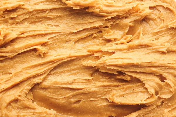 Manteiga de amendoim saborosa como fundo — Fotografia de Stock