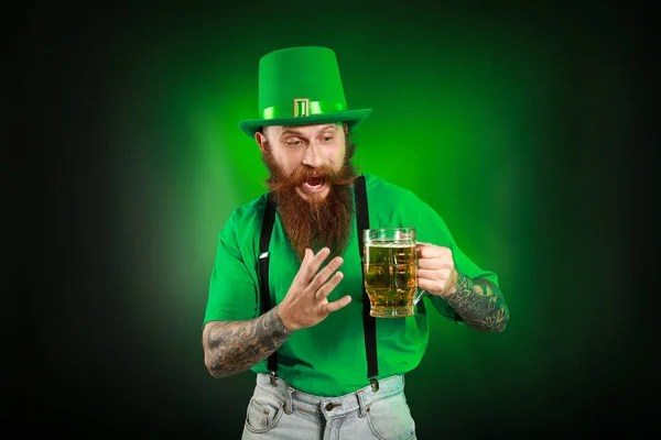 Hombre barbudo con un vaso de cerveza sobre fondo oscuro. Celebración del Día de San Patricio — Foto de Stock